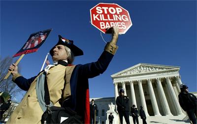 Противник на абортите, облечен като Джордж Вашингтон, държи пред Върховния съд на САЩ плакат "Спрете да убивате бебета"